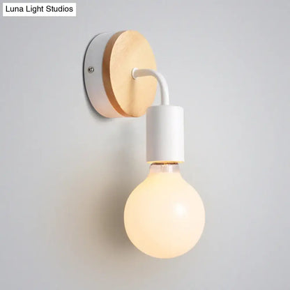 Minimalist bare bulb wall sconce with natural wood backplate and white metal arm for bedroom lighting