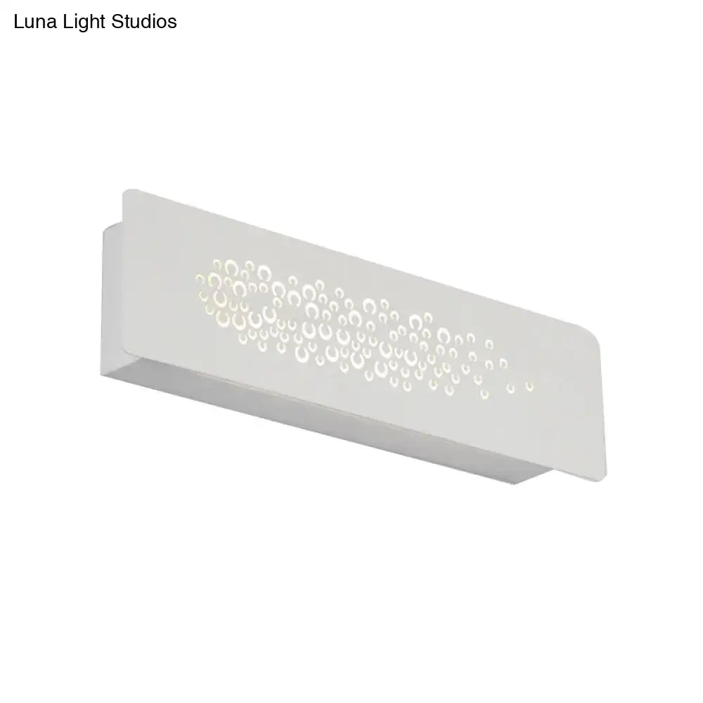 Minimalist white wall lamp with sturdy metal build and circular cutouts creating bubble pattern up and down light