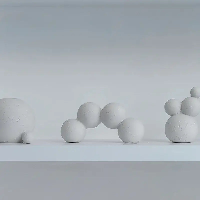 Minimalist white speckled geometric ceramic handicraft sphere sculpture with smooth matte gray surfaces and clustered design