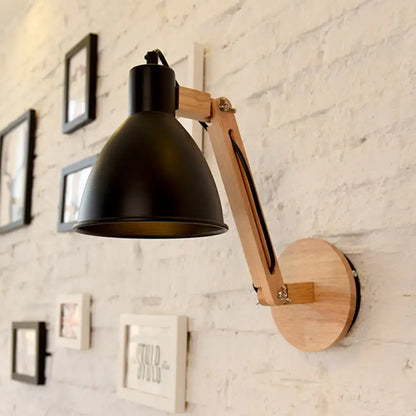 Black matte swing arm wall light with wooden articulated arm and circular base in white black finish for bedroom