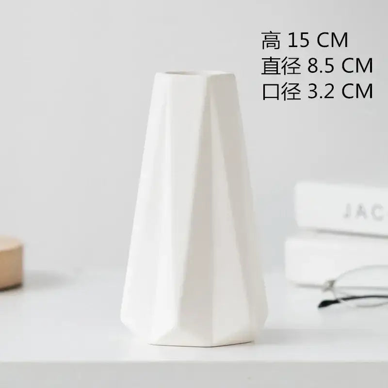 A sleek white decorbites ceramic vase with geometric faceted design and tapered shape for dining room decor