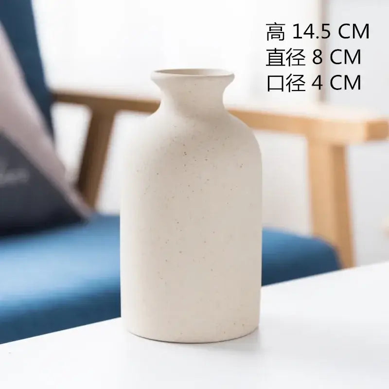 Cream-colored decorbites ceramic vase with subtle speckled texture and minimalist tapered design for dining room decor