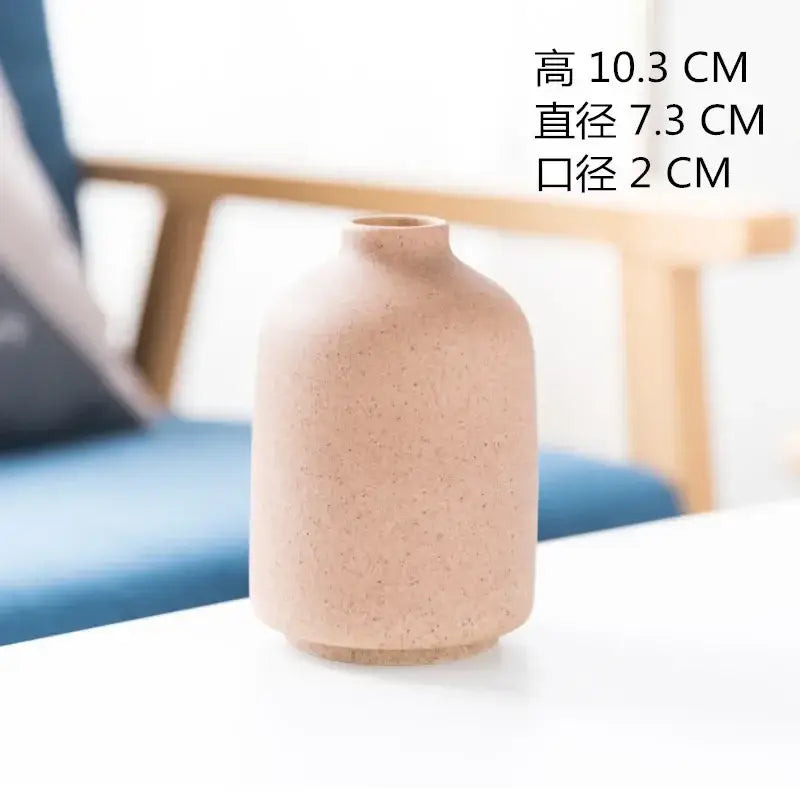 A matte beige speckled decorbites ceramic vase with rounded minimalist design for dining room decor