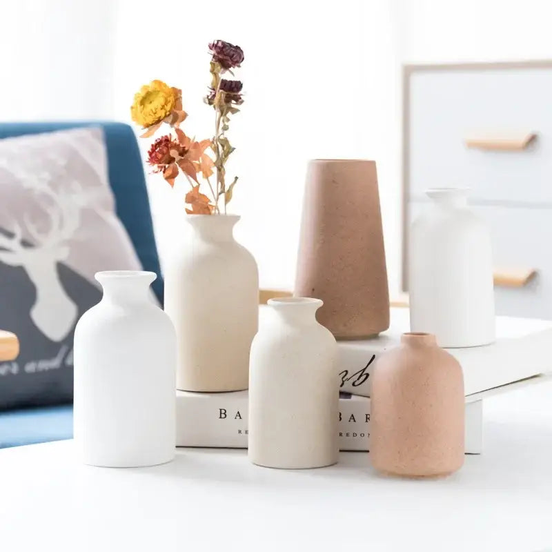 A collection of minimalist decorbites ceramic vases in white and terracotta with smooth rounded forms for dining room decor