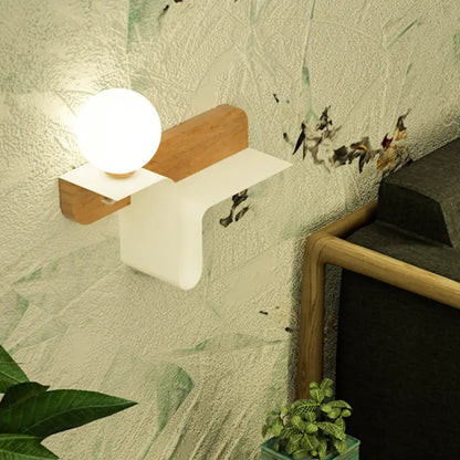 Minimalist white wall lamp with frosted glass shelf and spherical bulb in matte white plastic and light wood accents
