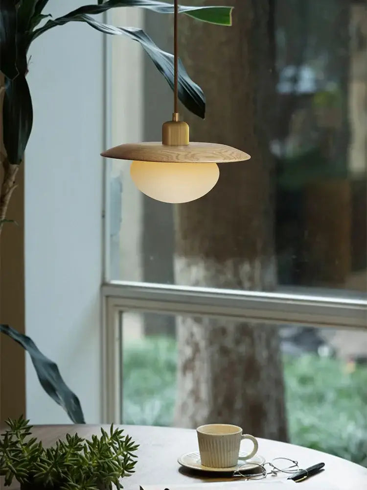 Minimalist wood and brass pendant lights with warm brass finish and glowing glass bulb for dining room decorbites cream wind