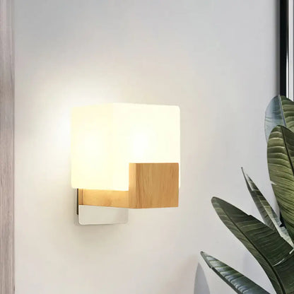 Minimalist wall sconce with frosted opal glass shade and light oak wood accent for bedroom wall light