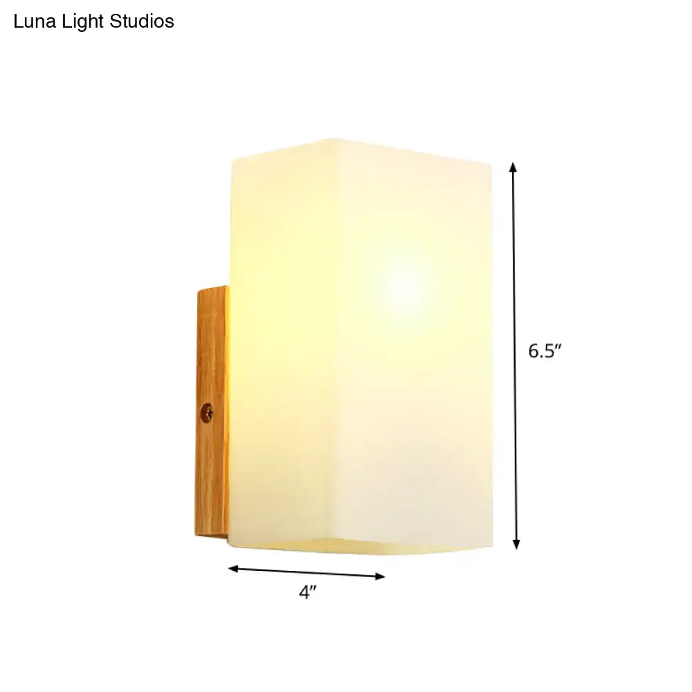 Minimalist wall sconce with frosted opal glass shade and natural wood bracket for modern bedroom wall light