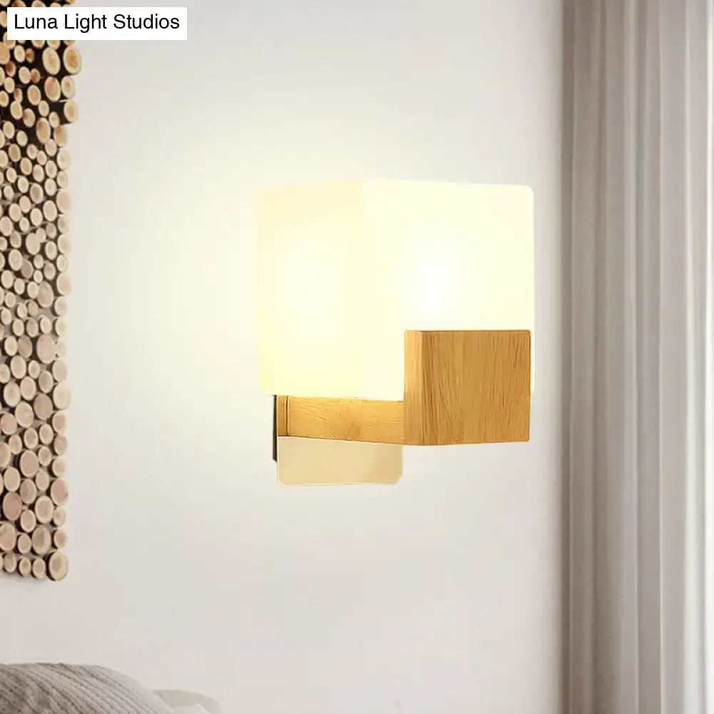 Minimalist wood and opal glass wall sconce with frosted shade providing warm, diffused light for bedroom wall light