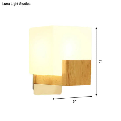 Minimalist wood and opal glass wall sconce with warm diffused glow and natural wood grain for bedroom wall light