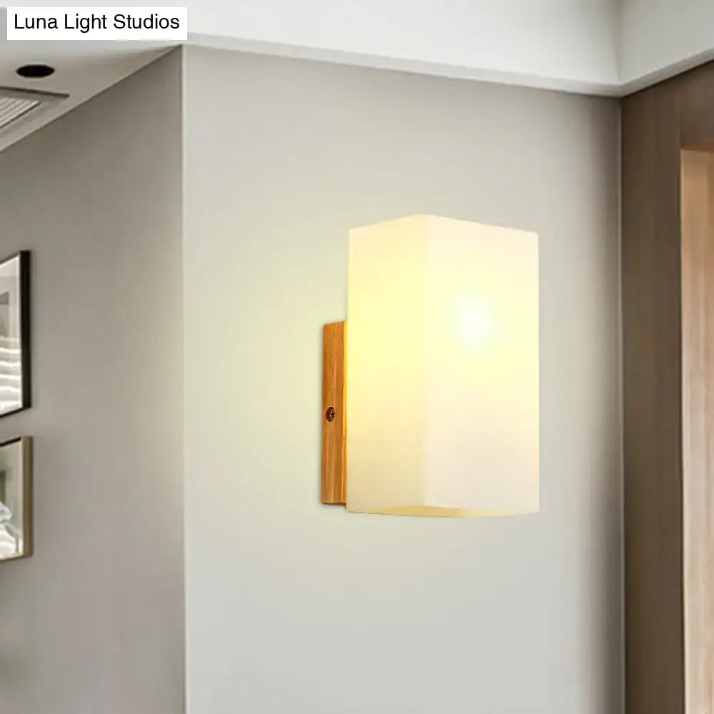 Minimalist warm-toned wall sconce with opal glass shade and bamboo-finished metal bracket for bedroom wall light
