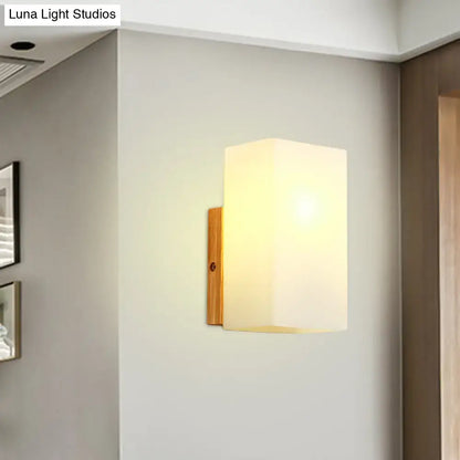 Minimalist warm-toned wall sconce with opal glass shade and bamboo-finished metal bracket for bedroom wall light