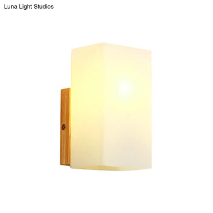 Minimalist warm-toned wall sconce with opal glass shade and natural wood bracket for bedroom wall light