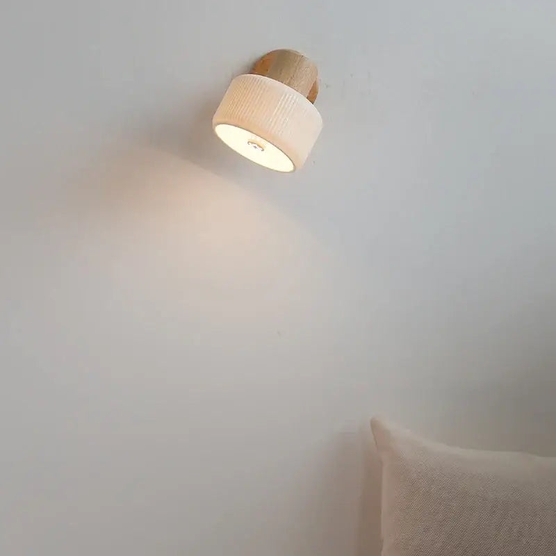 Minimalist wood and white ceramic led wall light with natural wood base and off-white ribbed fabric shade for bedroom decorbites led wall