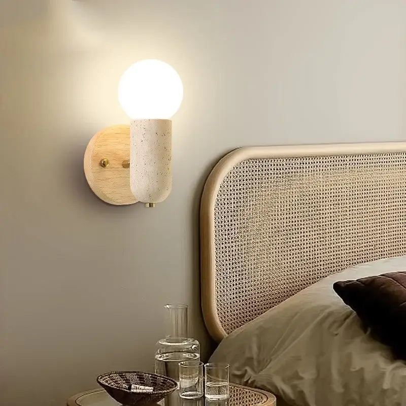 Minimalist wood and yellow travertine led wall sconce with warm glowing bulb on off-white textured concrete stem decorbites led wall