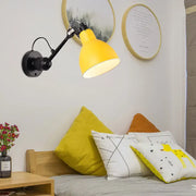 Minimalist yellow metal wall mounted lamp with black articulated arm and base for living room wall lamp use