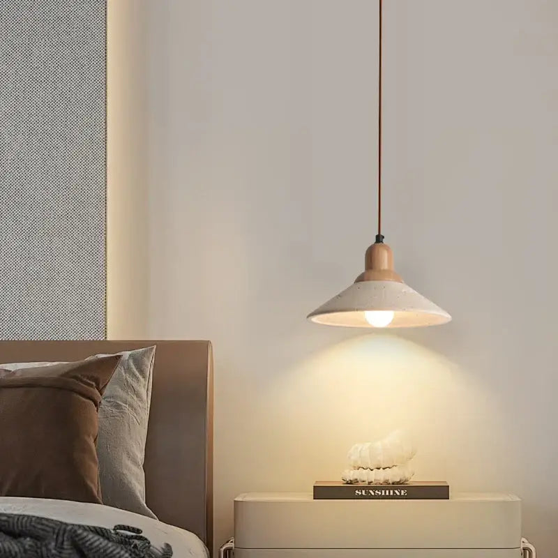 A warm-toned minimalist yellow travertine stone pendant light with matte concrete shade and wooden top for dining room