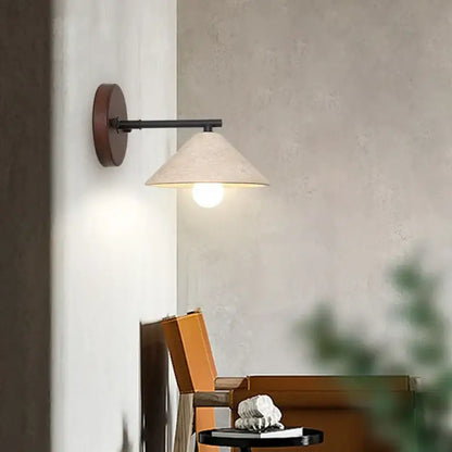 Minimalist wall light with yellow travertine and dark wood base featuring a black metal arm and textured off-white shade