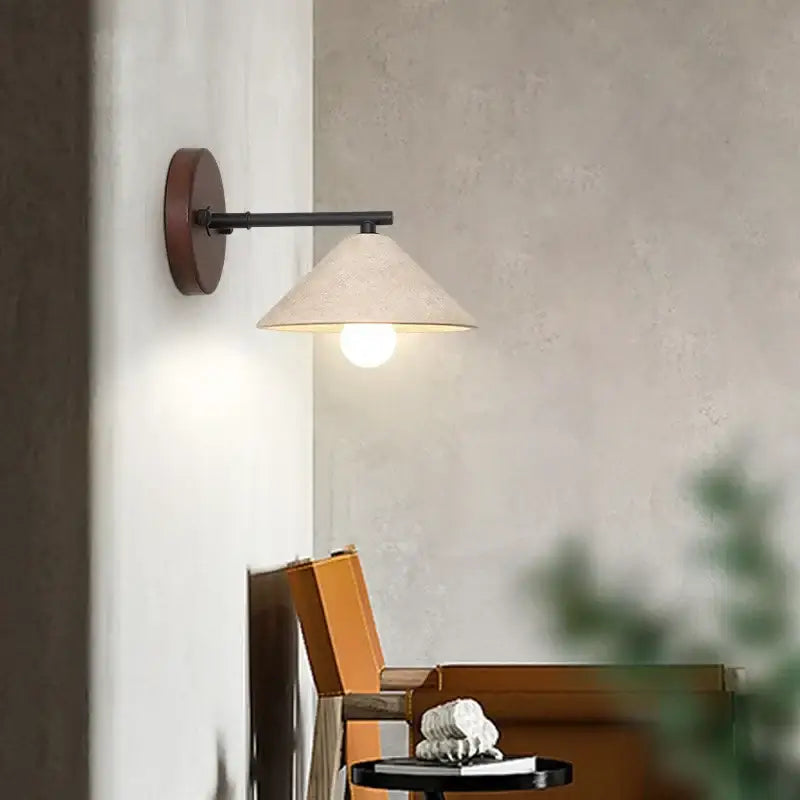 Minimalist wall light with yellow travertine and dark wood base featuring a black metal arm and textured off-white shade