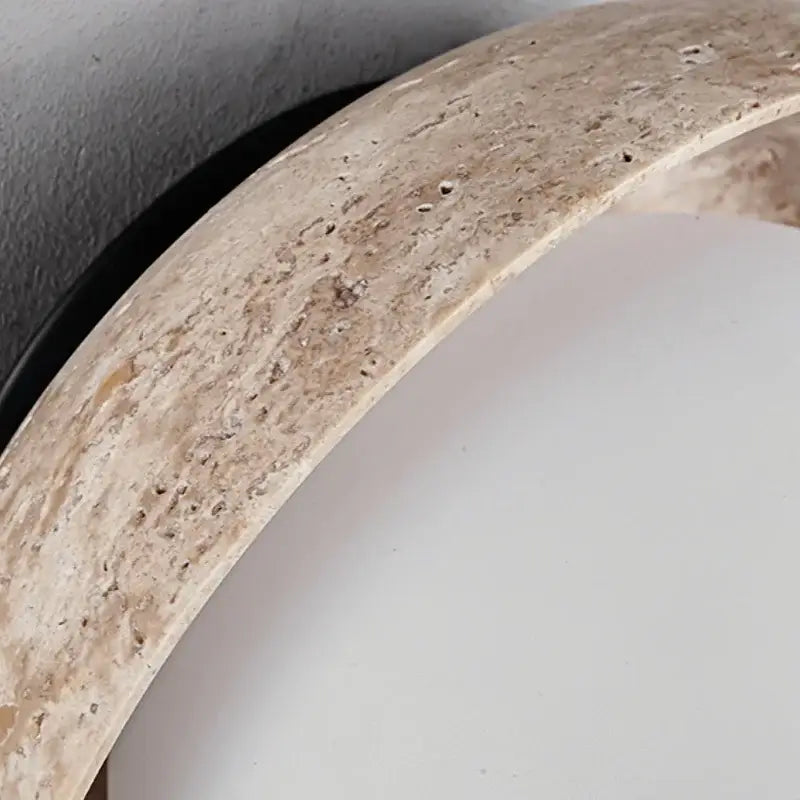 Beige stone mirror frame with textured natural finish complementing minimalist yellow travertine and decorbites led wall light