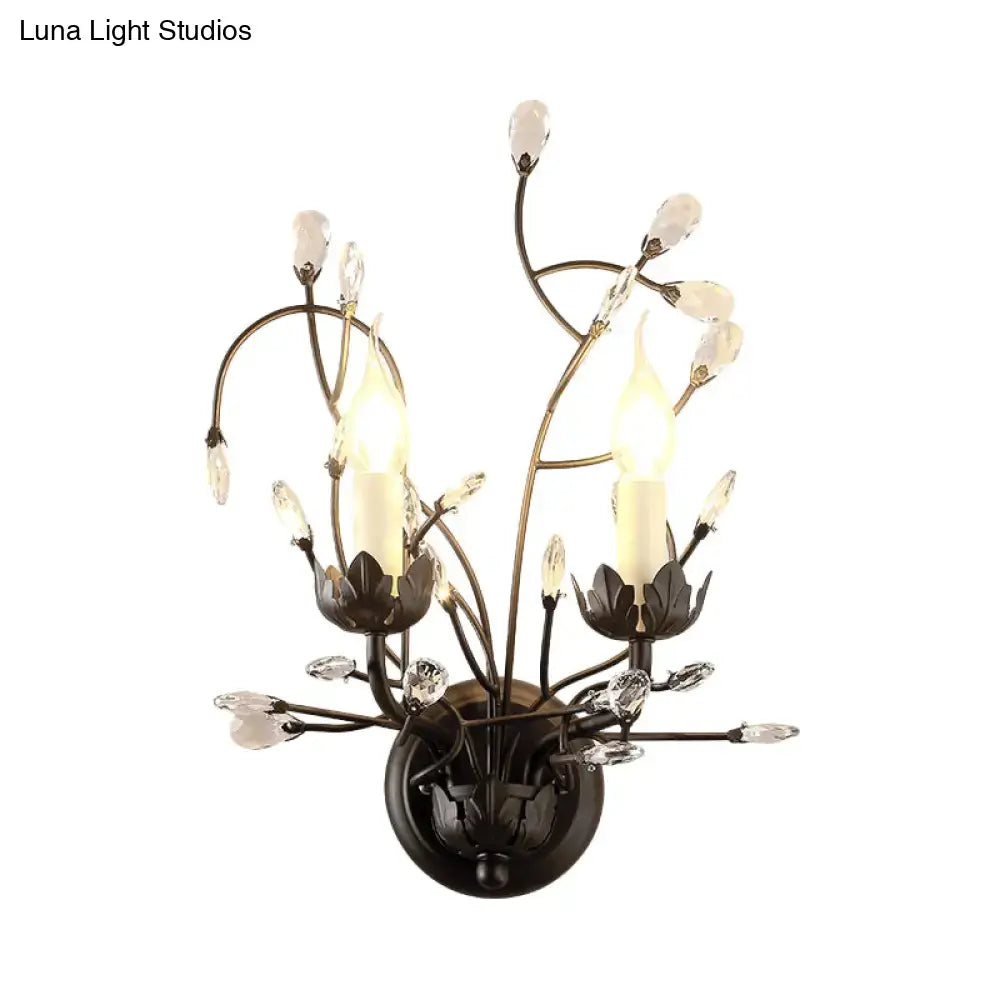 Antique bronze wall light sconce lamp with two candle-style lights and black crystal blossom accents for dining room
