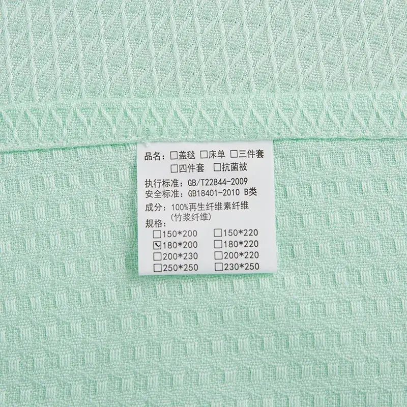 Mint green bamboo fiber cooling summer blanket with waffle texture and 100 percent regenerated cellulose fiber label by decorbites