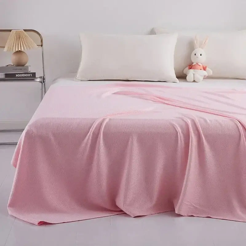 Soft pink textured blanket draped over bed in mint green bamboo fiber cooling summer blanket decorbites bamboo fiber design