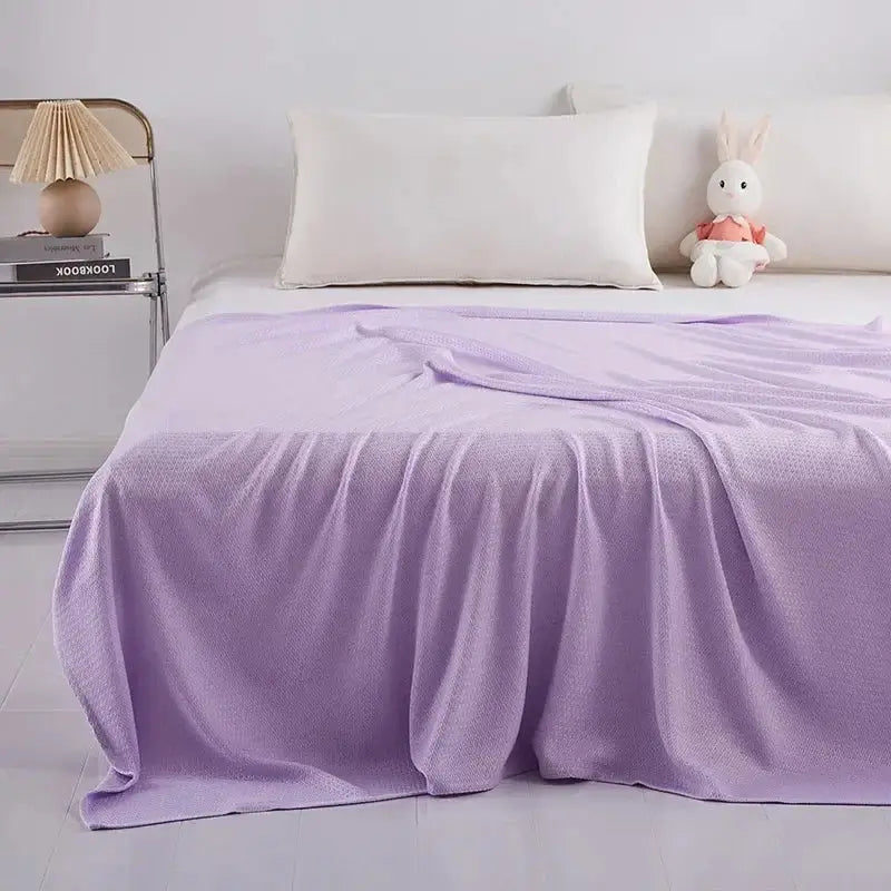 A soft lavender knit throw blanket with waffle texture complements the mint green decorbites bamboo fiber cooling summer blanket