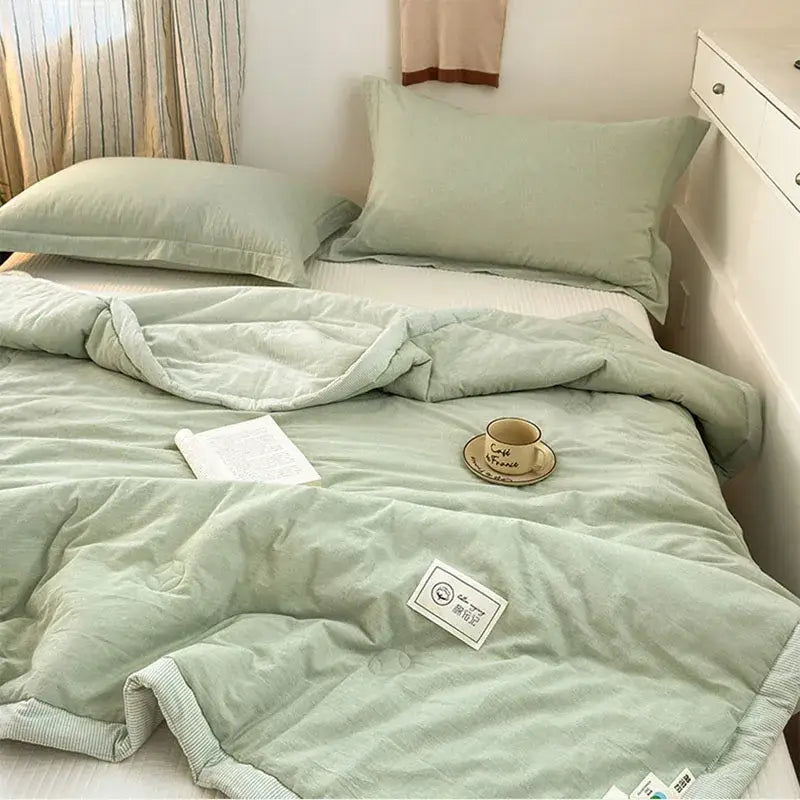 A soft mint green cotton summer cooling quilted comforter with subtle stripes and ribbed edge trim by decorbites cotton summer