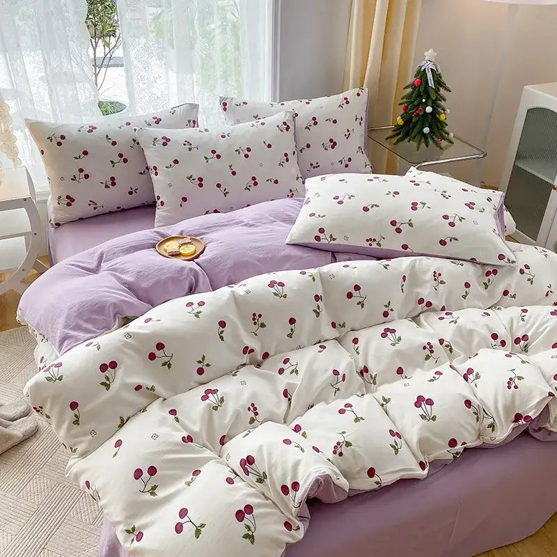 White quilted duvet cover with red cherry cartoon heart plant prints paired with matching pillowcases on lavender bedspread