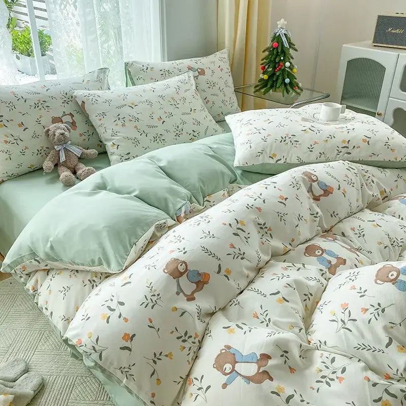 Cute beige teddy bear plush with white ribbon sitting on bed featuring mint green and cream cartoon heart plant quilt set