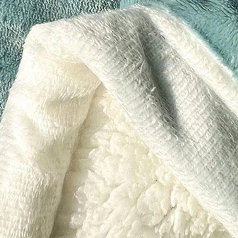 A plush mint green and cream decorbites cozy imitation lambs wool blanket with soft textured fleece and stitched edges