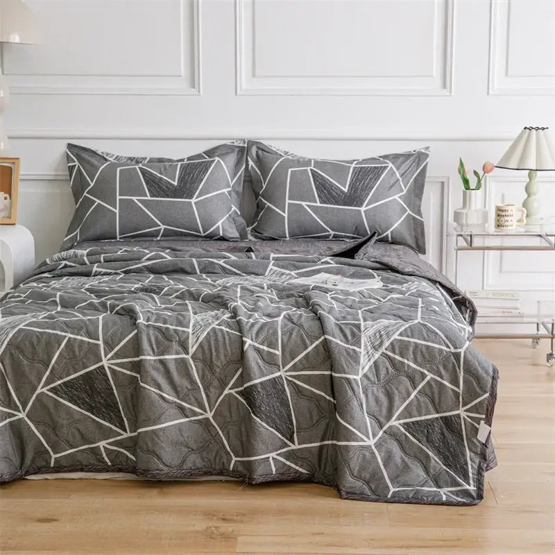Gray quilted comforter with geometric white line pattern and matching pillowcases from decorbites daisy print quilt set