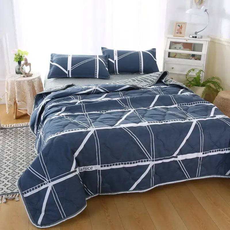 Navy blue quilted comforter with white geometric lines and stitching as part of decorbites daisy print quilt set bedding