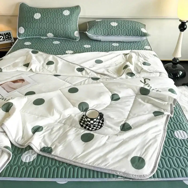 Mint green dinosaur summer quilt with white cotton quilt featuring green polka dots and subtle smile script with latex fitted sheet set