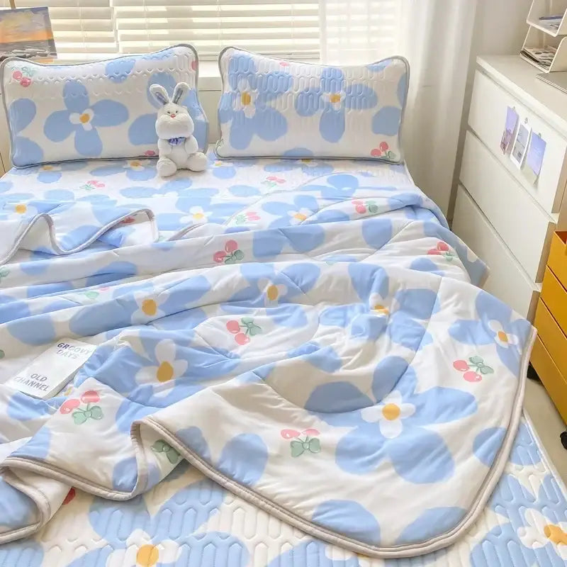 Blue and white floral patterned quilt set with embroidered details paired with a mint green latex fitted sheet set
