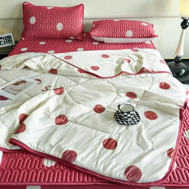 Pink and white polka dot quilted bed set with matching pillow sham paired with mint green dinosaur latex fitted sheet set