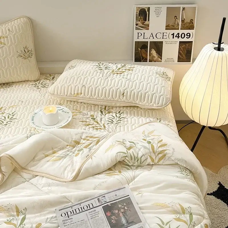 Cream-colored quilted bed set with green and gold leaf embroidery featuring a latex fitted sheet set for summer use