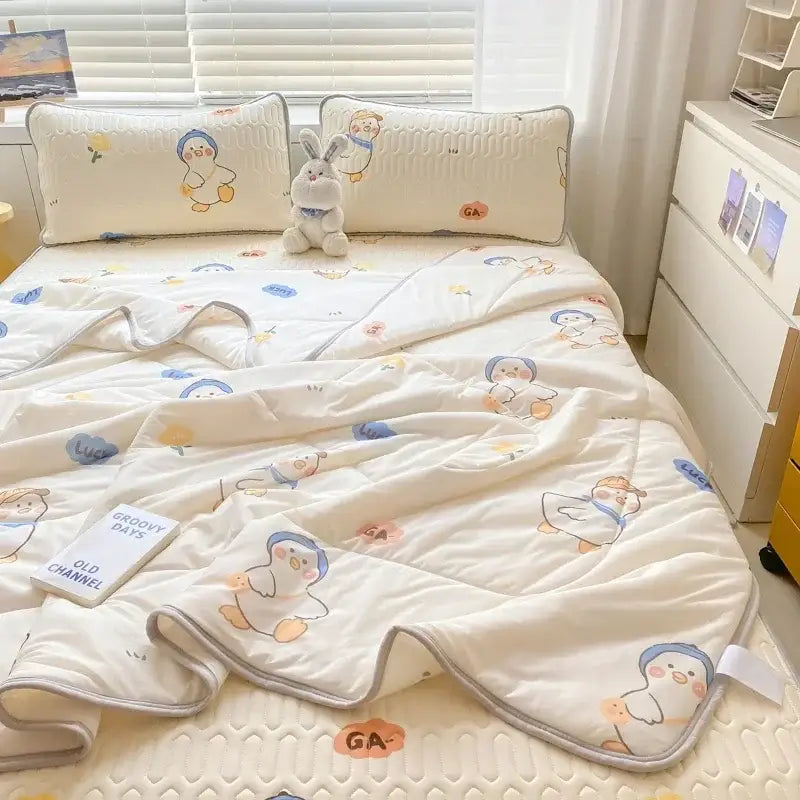 Cream-colored quilted blanket with cartoon penguins and gray piping in mint green dinosaur summer quilt and fitted sheet set