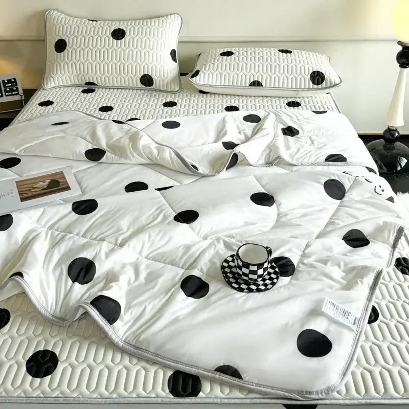 White quilted bed set with black polka dots and silver trim featuring a latex fitted sheet set in a dinosaur bedroom