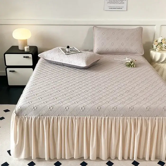 Beige quilted bed skirt set with subtle diamond pattern and ruffled hem for bedroom mattress mat use