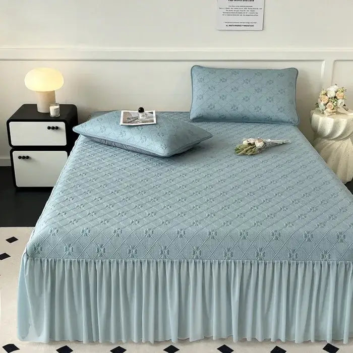 Light blue quilted bed skirt set with subtle floral pattern and ruffled hem for bedroom mattress mat use