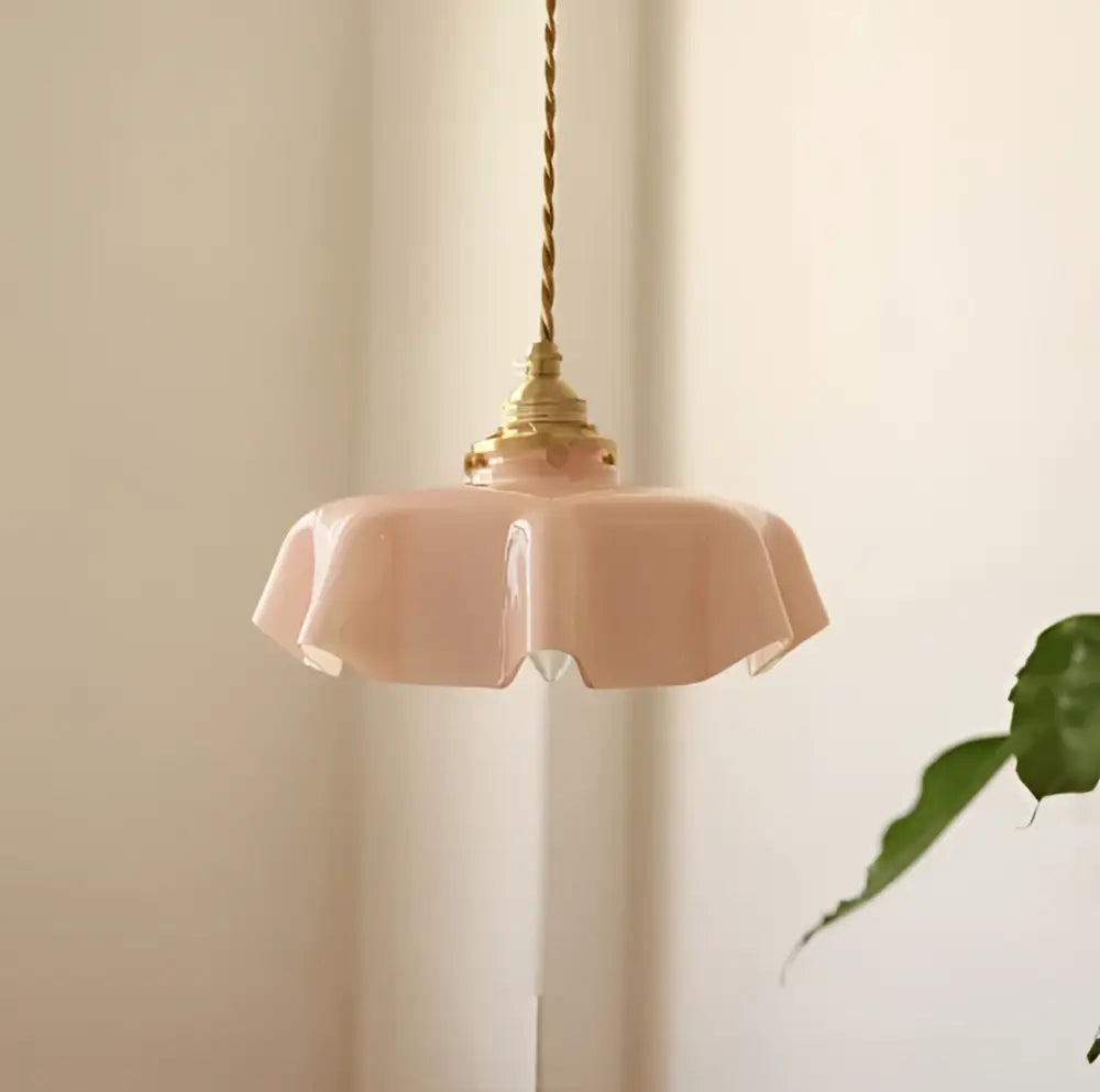 A delicate pink fluted glass led wall lamp sconce with brass hardware for bedroom lighting