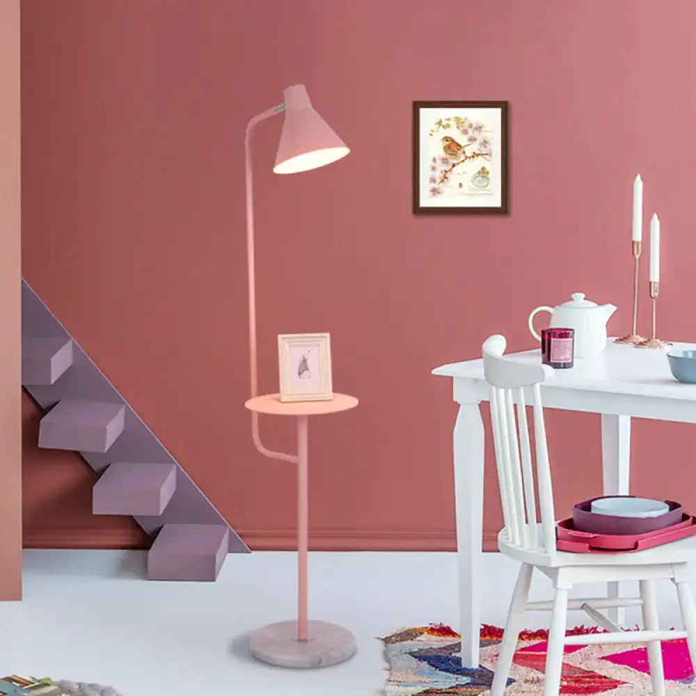Pink DecorBites™ macaron floor lamp with metal shade and funnel shaped design beside circular side table