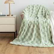 A soft mint green plush geometric jacquard flannel sofa cover draped over an armchair for living room decor