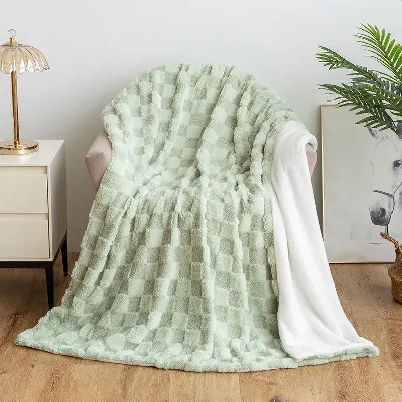 A soft mint green geometric jacquard flannel sofa cover with a textured checkered pattern and white lining