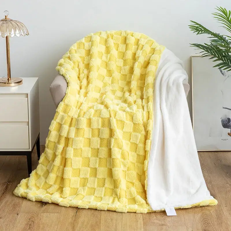 A cozy yellow and white checkered plush blanket with a soft texture paired with mint green geometric jacquard flannel sofa cover decorbites