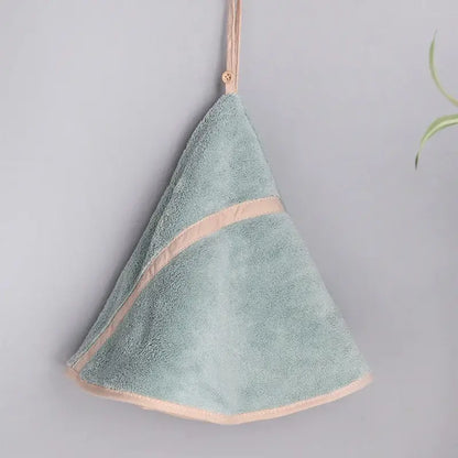A soft mint green decorbites coral velvet hand towel with delicate peach trim and hanging loop for bathroom use