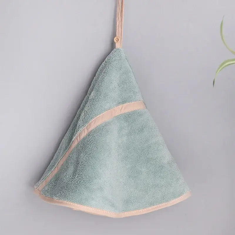 A soft mint green decorbites coral velvet hand towel with delicate peach trim and hanging loop for bathroom use