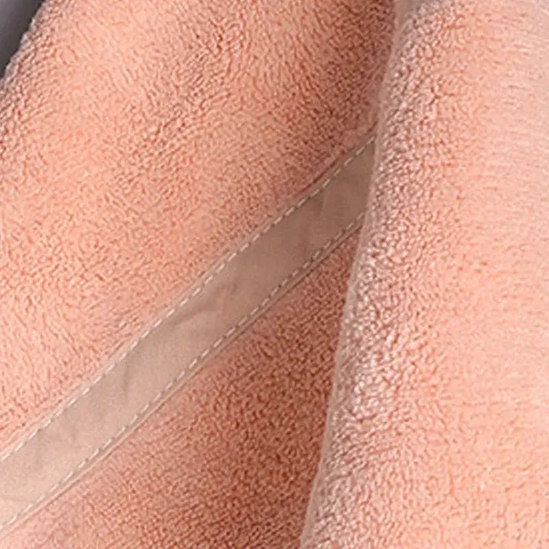 Soft peach-colored terry cloth hand towel with beige stitched seam from decorbites coral velvet hand towel set